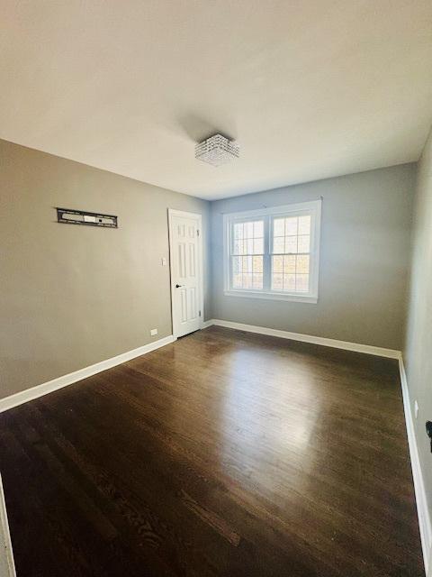 2544 W 107th St, Chicago, IL 60655 - spare room featuring baseboards and dark wood-style floors