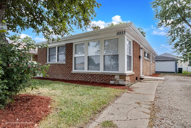 15223 Cottage Grove Ave, Dolton, IL 60419 - view of front of home featuring brick siding, a detached garage, a front yard, and an outdoor structure