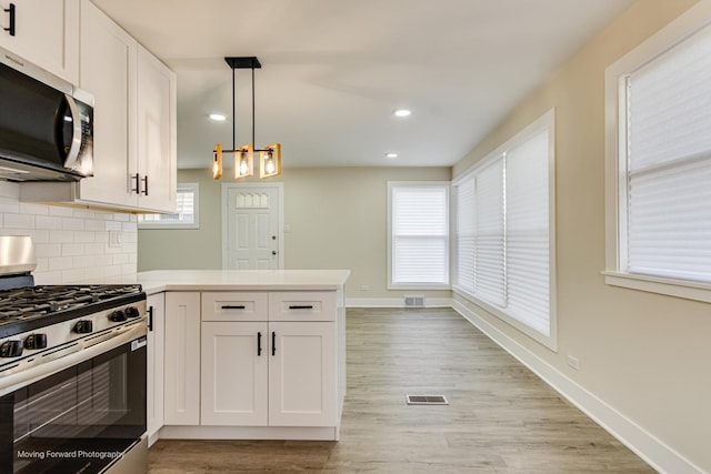 15223 Cottage Grove Ave, Dolton, IL 60419 - kitchen featuring appliances with stainless steel finishes, a peninsula, white cabinetry, backsplash, and recessed lighting