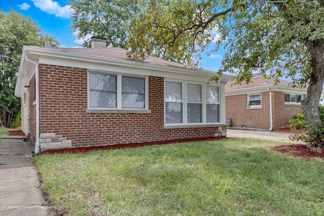 15223 Cottage Grove Ave, Dolton, IL 60419 - view of front of home with brick siding, a front yard, and a chimney