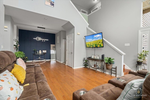 2039 Muirfield Dr, Yorkville, IL 60560 - living room with stairs, wood-type flooring, a towering ceiling, and a chandelier
