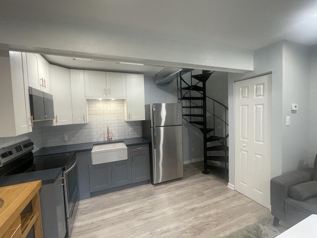 64 Aspen Colony Unit 5, Fox Lake, IL 60020 - kitchen with stainless steel appliances, dark countertops, white cabinets, light wood finished floors, and tasteful backsplash