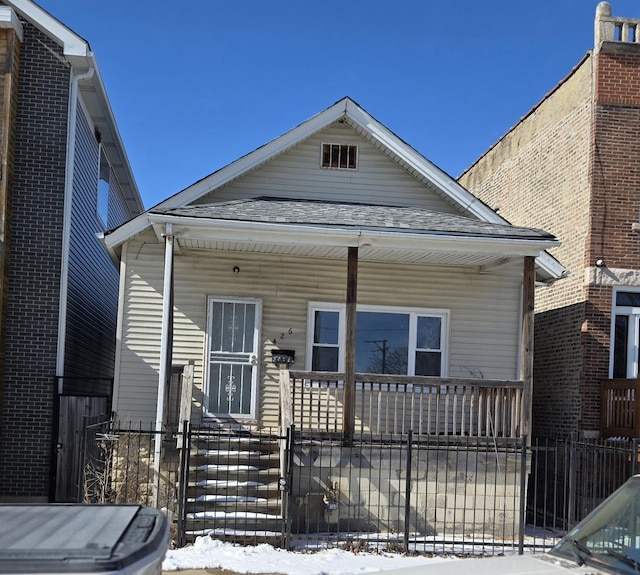 426 N Trumbull Ave, Chicago, IL 60624 - view of front of property featuring covered porch, a fenced front yard, and roof with shingles