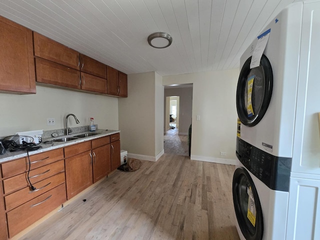 426 N Trumbull Ave, Chicago, IL 60624 - kitchen featuring stacked washer / drying machine, light wood-type flooring, brown cabinets, and wooden ceiling