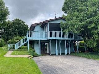 71 Delburne Dr, Davis, IL 61019 - view of front facade with a wooden deck, a front lawn, stairs, and driveway
