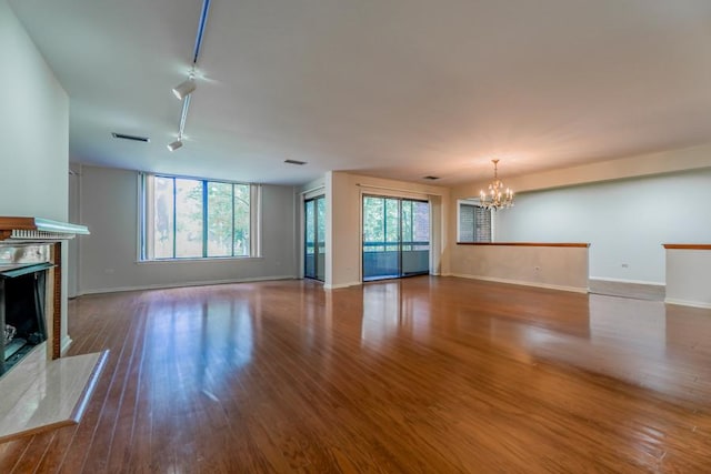 1401 Burr Oak Rd Unit 108B, Hinsdale, IL 60521 - unfurnished living room featuring a chandelier, a fireplace, and wood finished floors