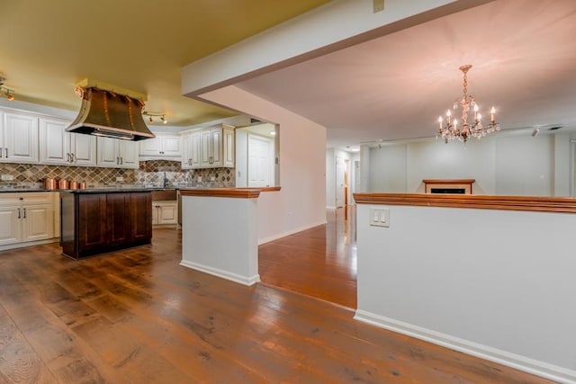 1401 Burr Oak Rd Unit 108B, Hinsdale, IL 60521 - kitchen with decorative backsplash, dark wood-style floors, a chandelier, island range hood, and dark countertops