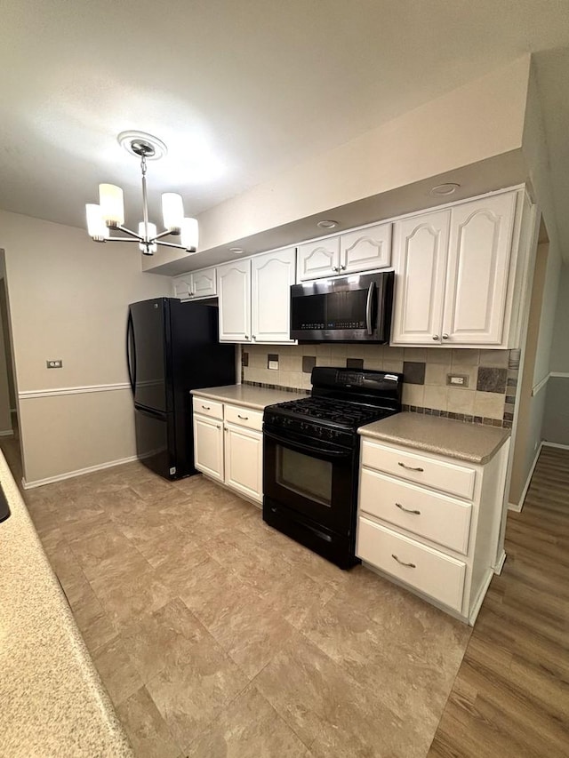 2S651 Ashley Dr, Glen Ellyn, IL 60137 - kitchen featuring black appliances, white cabinetry, a chandelier, decorative backsplash, and pendant lighting