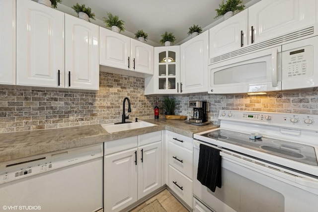 111 E Chestnut St Unit 21B, Chicago, IL 60611 - kitchen featuring white appliances, white cabinetry, tasteful backsplash, glass insert cabinets, and light countertops