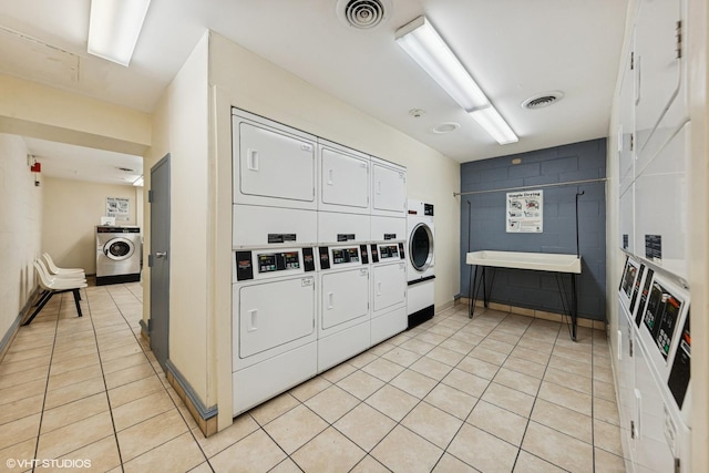 111 E Chestnut St Unit 21B, Chicago, IL 60611 - shared laundry with stacked washer and clothes dryer, light tile patterned floors, and concrete block wall