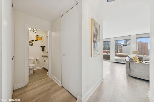 111 E Chestnut St Unit 21B, Chicago, IL 60611 - hall featuring light wood-style floors, radiator, and a chandelier