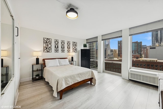 111 E Chestnut St Unit 21B, Chicago, IL 60611 - bedroom featuring radiator heating unit, wood finished floors, a view of city, a wall of windows, and access to exterior