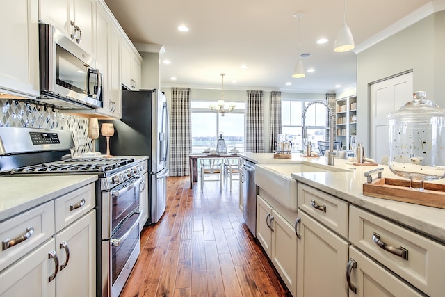 1552 Times Dr, Des Plaines, IL 60018 - kitchen featuring stainless steel appliances, ornamental molding, dark wood-type flooring, white cabinets, and decorative light fixtures
