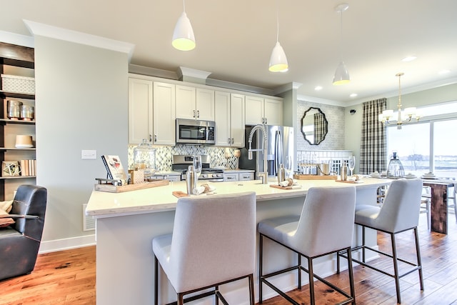 1552 Times Dr, Des Plaines, IL 60018 - kitchen with appliances with stainless steel finishes, crown molding, decorative backsplash, light wood-style floors, and a kitchen breakfast bar