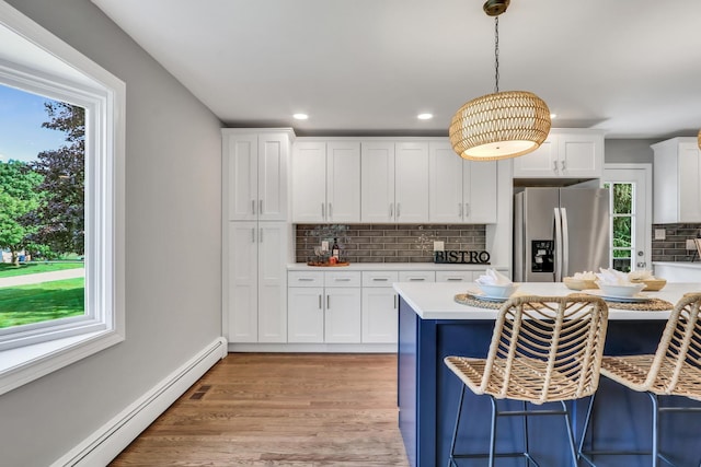 31340 N Liberty Rd, Grayslake, IL 60030 - kitchen with stainless steel fridge, a baseboard heating unit, a breakfast bar area, backsplash, and pendant lighting