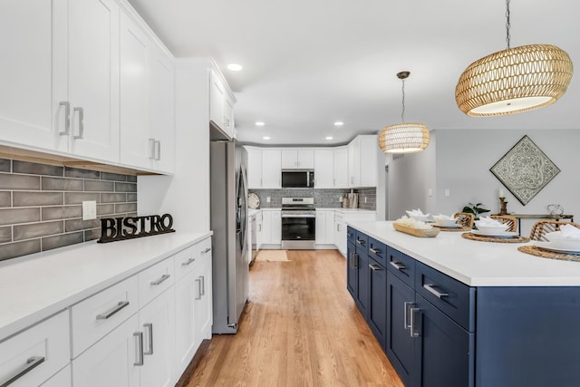 31340 N Liberty Rd, Grayslake, IL 60030 - kitchen featuring stainless steel appliances, blue cabinetry, white cabinets, tasteful backsplash, and light countertops