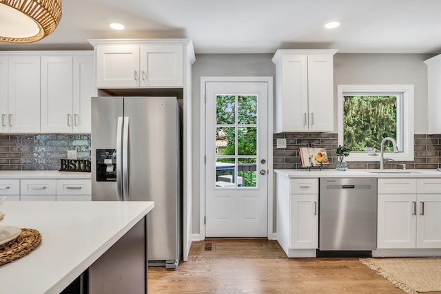 31340 N Liberty Rd, Grayslake, IL 60030 - kitchen with stainless steel appliances, recessed lighting, healthy amount of natural light, decorative backsplash, and white cabinets