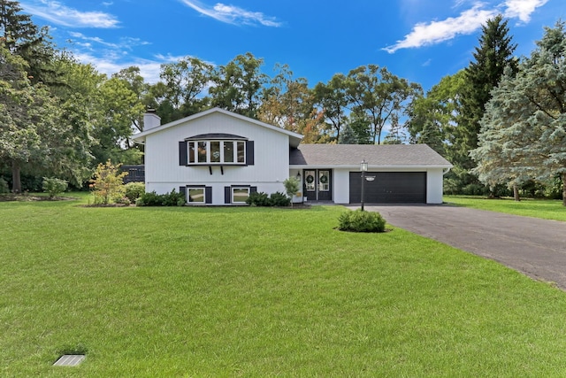 31340 N Liberty Rd, Grayslake, IL 60030 - split level home featuring an attached garage, a front lawn, asphalt driveway, and a chimney