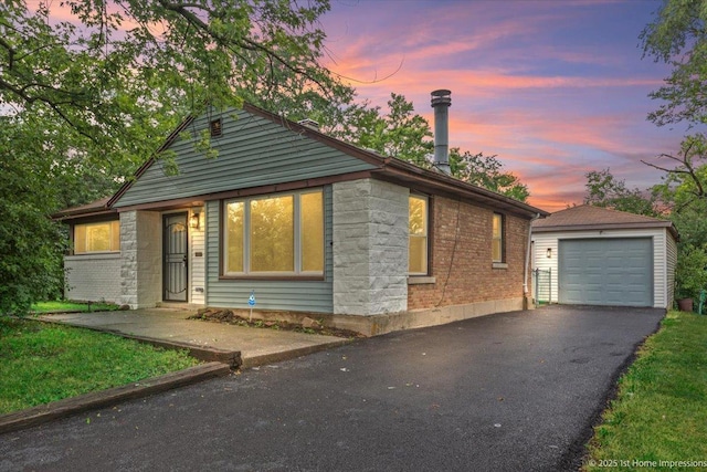 214 Marquette St, Park Forest, IL 60466 - bungalow-style home featuring an outbuilding, asphalt driveway, a detached garage, and brick siding