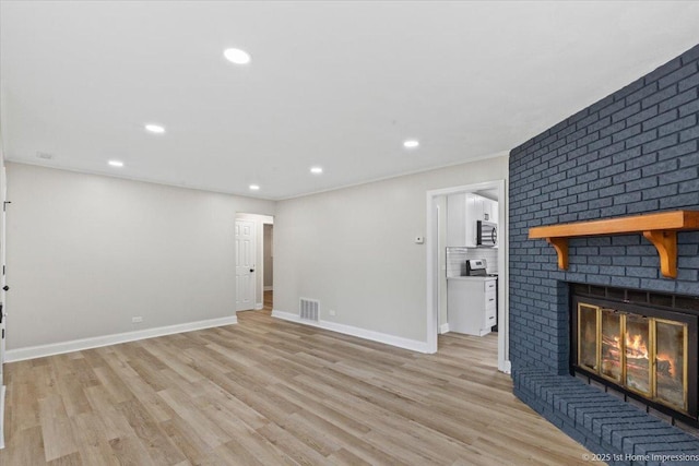 214 Marquette St, Park Forest, IL 60466 - unfurnished living room featuring a brick fireplace, light wood-style flooring, and recessed lighting