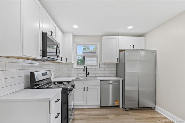 214 Marquette St, Park Forest, IL 60466 - kitchen featuring stainless steel appliances, white cabinetry, light countertops, decorative backsplash, and light wood finished floors