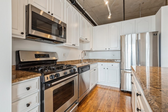 6 S Laflin St Unit 712, Chicago, IL 60607 - kitchen featuring stainless steel appliances, light wood finished floors, dark stone countertops, and white cabinetry