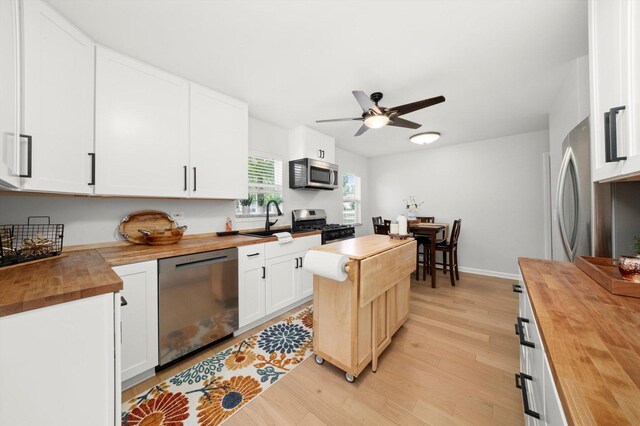 17011 Le Claire Ave, Tinley Park, IL 60477 - kitchen with wooden counters, light wood-style flooring, appliances with stainless steel finishes, a ceiling fan, and white cabinetry