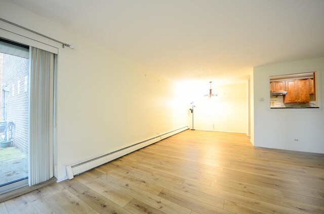 1206 S New Wilke Rd Unit 108, Arlington Heights, IL 60005 - empty room with a baseboard radiator, light wood finished floors, and a chandelier