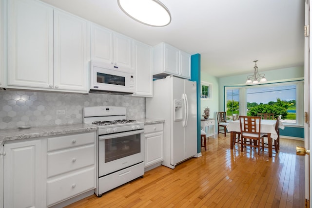 22869 W Lake Shore Dr, Antioch, IL 60002 - kitchen featuring white appliances, a chandelier, backsplash, and white cabinets