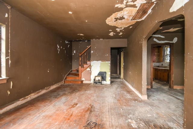 8645 S Bennett Ave, Chicago, IL 60617 - unfurnished living room with arched walkways, stairway, and wood-type flooring