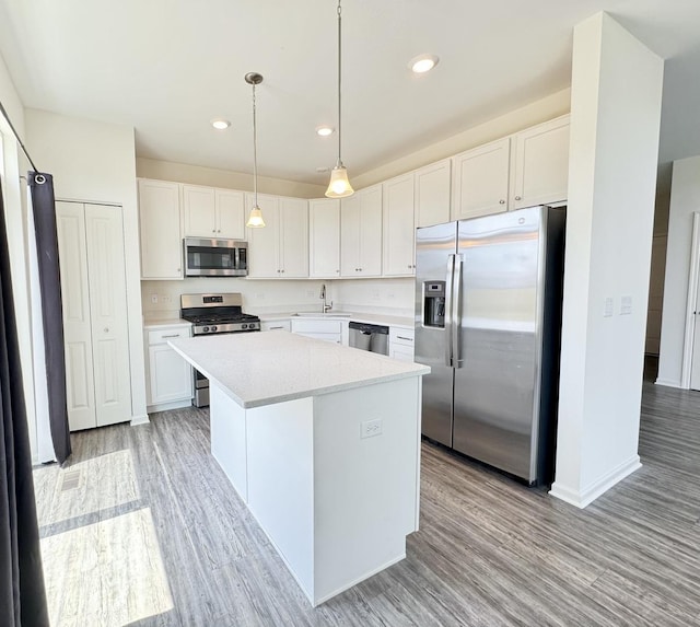 15041 W Quincy Cir, Manhattan, IL 60442 - kitchen with stainless steel appliances, light wood-style flooring, a center island, light countertops, and recessed lighting