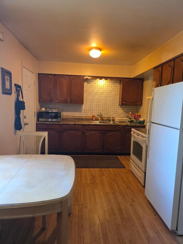 264 Bay St, Wood Dale, IL 60191 - kitchen featuring white appliances, light wood-type flooring, dark countertops, and decorative backsplash