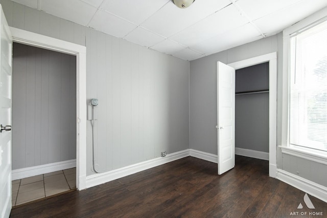 1229 E 71st St, Chicago, IL 60619 - unfurnished bedroom featuring dark wood-style flooring, multiple windows, a paneled ceiling, and a closet