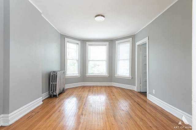 1229 E 71st St, Chicago, IL 60619 - spare room featuring radiator, plenty of natural light, light wood-style floors, and ornamental molding