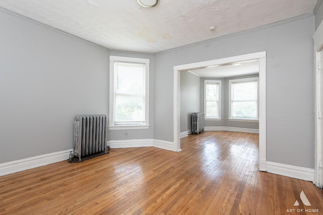 1229 E 71st St, Chicago, IL 60619 - unfurnished room with radiator, light wood-style flooring, and crown molding