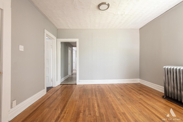 1229 E 71st St, Chicago, IL 60619 - spare room with radiator heating unit and light wood-style flooring