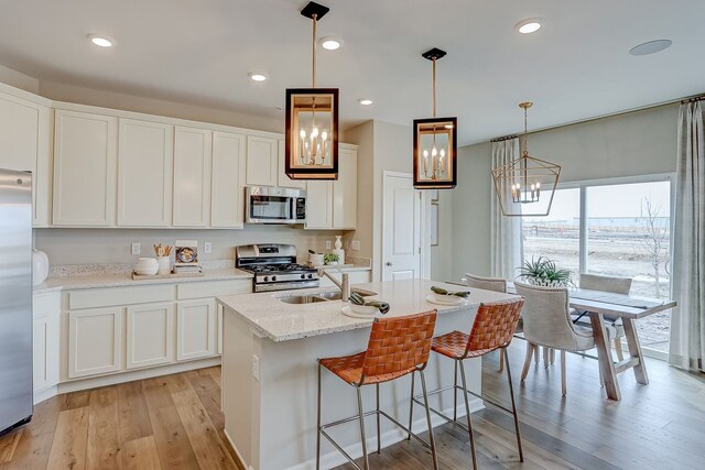 1647 Patterson Ave, North Aurora, IL 60542 - kitchen featuring stainless steel appliances, light wood-style floors, a chandelier, white cabinetry, and recessed lighting