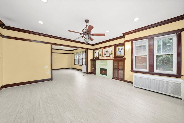 5019 N Kostner Ave, Chicago, IL 60630 - unfurnished living room featuring radiator, ornamental molding, ceiling fan, a warm lit fireplace, and wood finished floors