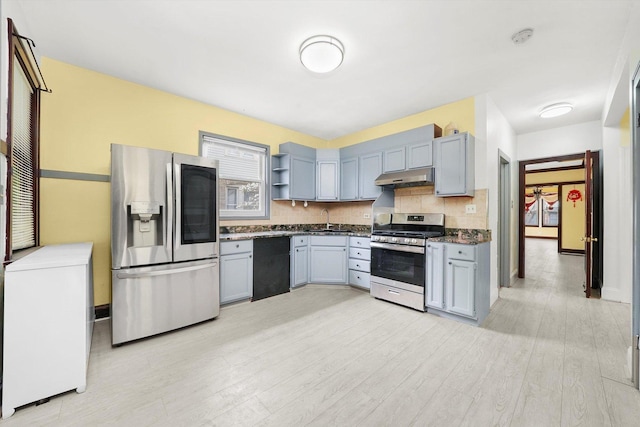 5019 N Kostner Ave, Chicago, IL 60630 - kitchen with appliances with stainless steel finishes, under cabinet range hood, open shelves, tasteful backsplash, and light wood finished floors