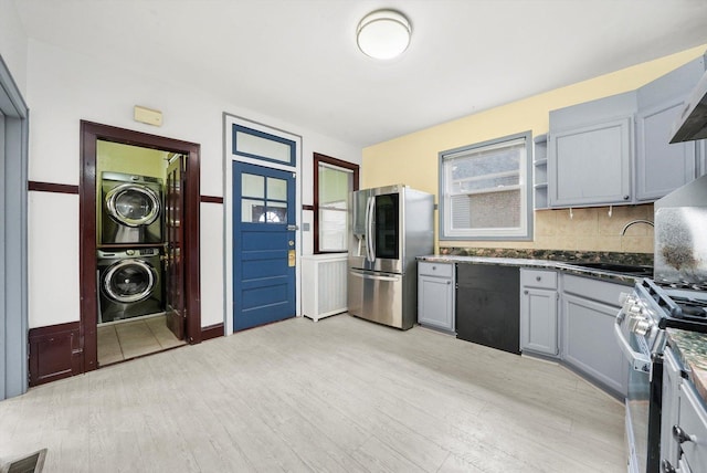 5019 N Kostner Ave, Chicago, IL 60630 - kitchen with appliances with stainless steel finishes, stacked washer / drying machine, gray cabinets, and light wood-type flooring