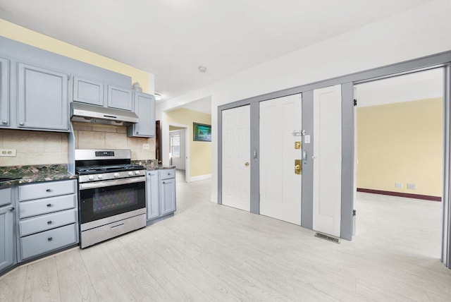 5019 N Kostner Ave, Chicago, IL 60630 - kitchen featuring gas range, under cabinet range hood, decorative backsplash, light wood-style floors, and gray cabinetry