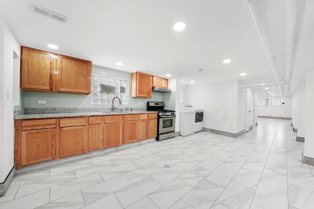 5019 N Kostner Ave, Chicago, IL 60630 - kitchen with stainless steel gas range, under cabinet range hood, washer / clothes dryer, recessed lighting, and light stone countertops