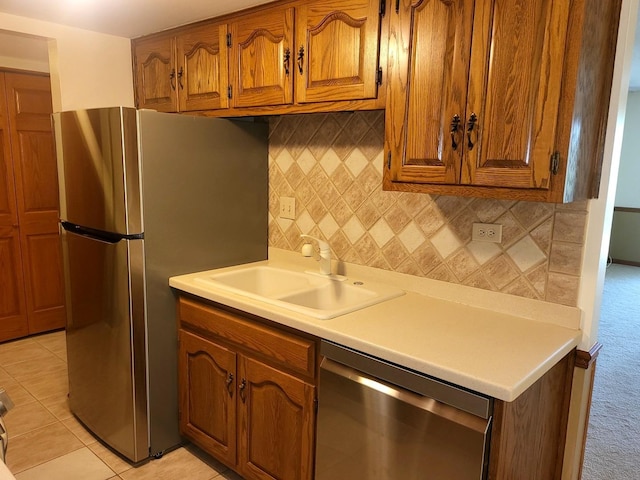 505 Redondo Dr Unit 108, Downers Grove, IL 60515 - kitchen featuring stainless steel appliances, brown cabinets, decorative backsplash, light countertops, and light carpet