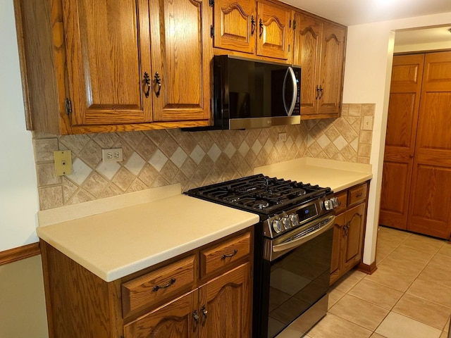 505 Redondo Dr Unit 108, Downers Grove, IL 60515 - kitchen with stainless steel gas range oven, black microwave, brown cabinetry, tasteful backsplash, and light countertops