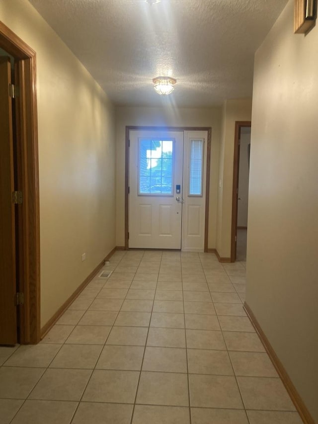 831 Oriole Dr, Peotone, IL 60468 - doorway with light tile patterned floors and a textured ceiling