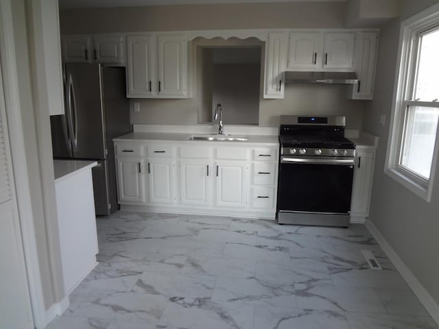 210 Caddy Ave, Carpentersville, IL 60110 - kitchen featuring appliances with stainless steel finishes, light marble finish flooring, under cabinet range hood, and healthy amount of natural light