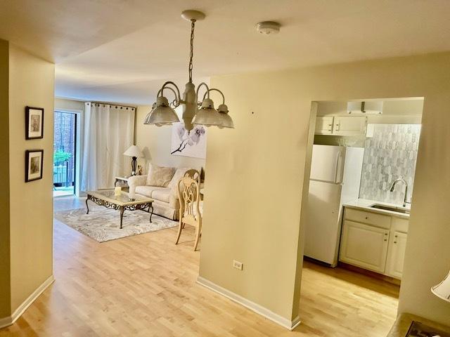 2317 N Neva Ave Unit 106A, Chicago, IL 60707 - dining space featuring a chandelier and light wood-style flooring
