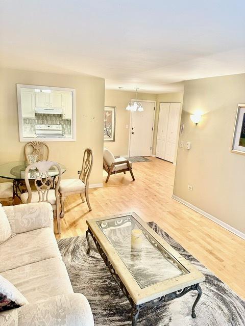 2317 N Neva Ave Unit 106A, Chicago, IL 60707 - living area featuring light wood finished floors and a chandelier
