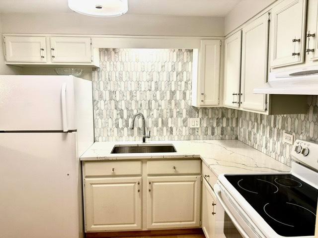 2317 N Neva Ave Unit 106A, Chicago, IL 60707 - kitchen featuring white appliances, light stone counters, and white cabinetry