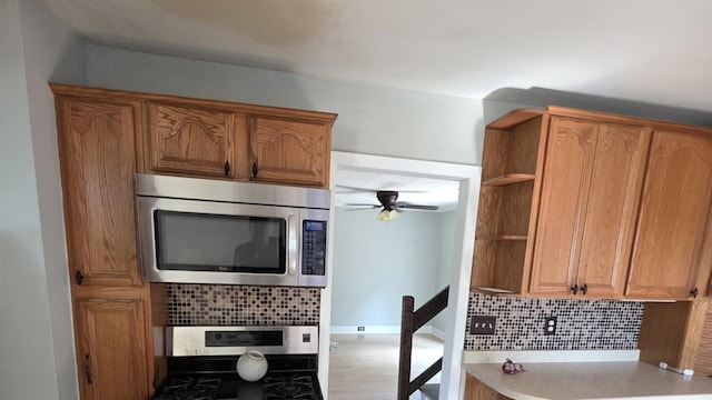 302 Dee Rd, North Aurora, IL 60542 - kitchen with stainless steel appliances, tasteful backsplash, open shelves, ceiling fan, and light countertops